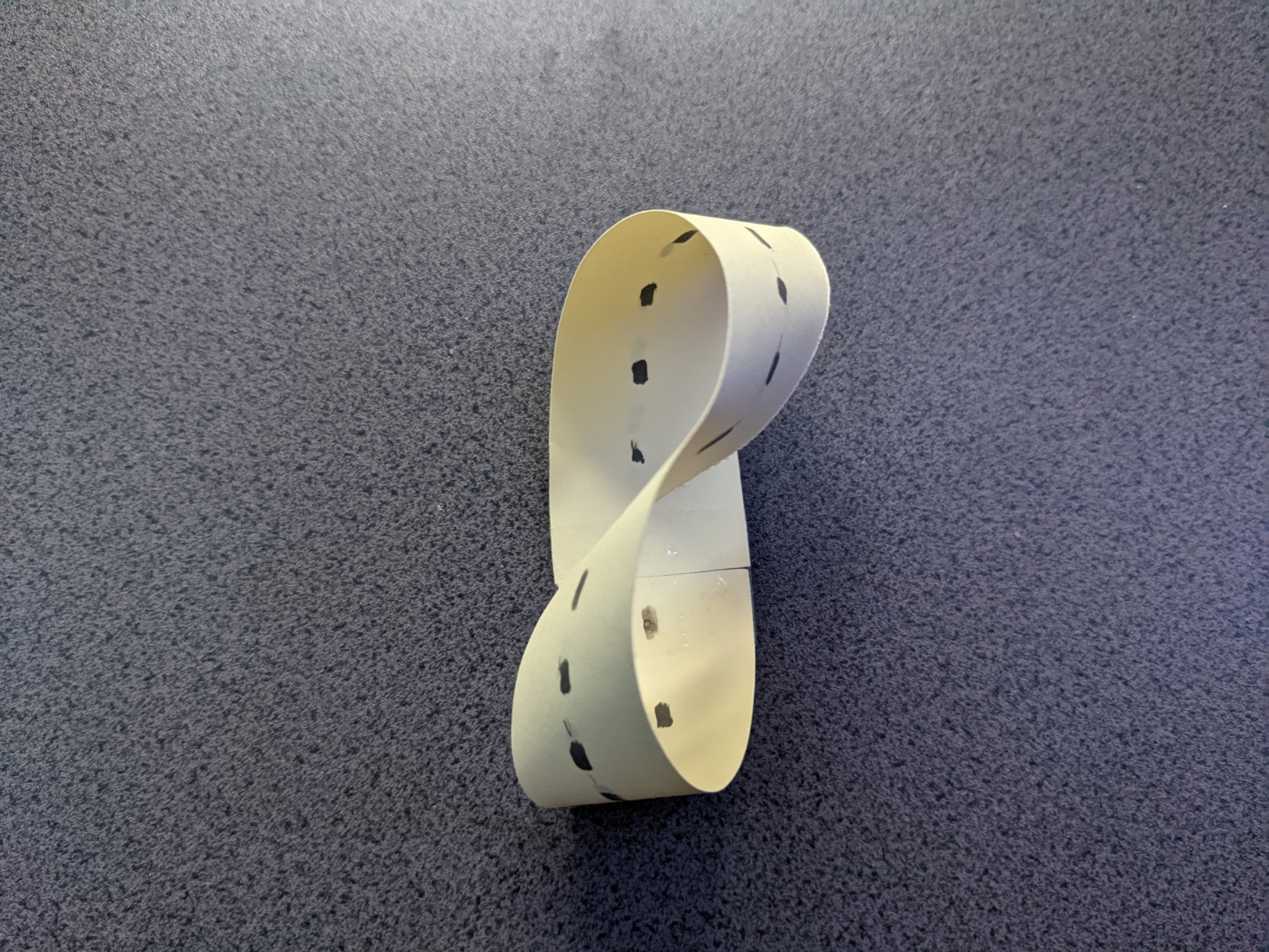 A strip of card with its ends taped together to form a loop with a single twist in it